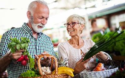 A couple picking out vegetables at a farmer’s market