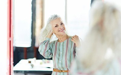 Woman looking in her mirror and smiling