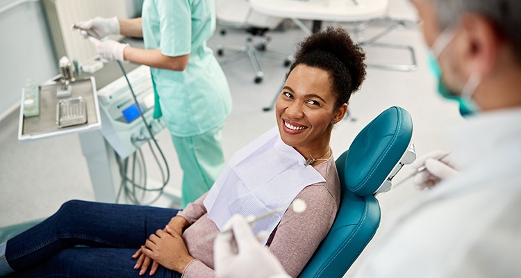 Dentist talking to smiling patient in treatment chair